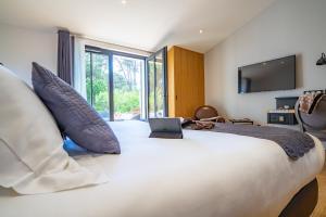 a bedroom with a large bed with a laptop on it at Hôtel Ile de Ré in Le Bois-Plage-en-Ré