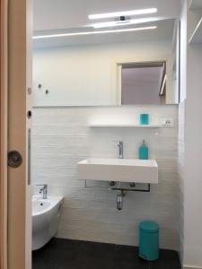 a white bathroom with a sink and a mirror at Mizzika Vacanze in Castellammare del Golfo +48 photos