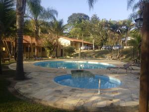 a swimming pool in a yard with a palm tree at Pousada Sarapui in Sarapuí