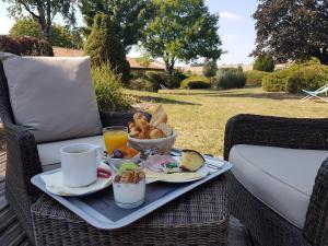 a tray of breakfast food on a wicker chair at Kyriad Angoulême Nord Champniers- Hôtel & Résidence in Champniers