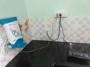 a kitchen with pink and white tiles on the wall at Dio's Guest House in Utorda