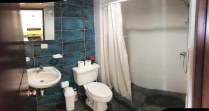 
a bathroom with a toilet a sink and a shower at Condo Villa Marbella in Santo Domingo
