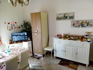 a room with a table and a refrigerator and a table and chairs at B&B La Felicità in Lesina