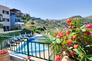 a view of a pool from a balcony with flowers at Erivolos Studios & Apartments in Lygaria