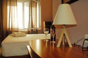 uma mesa com um candeeiro e copos de vinho em Alexander Rooms & Apartments em Igoumenitsa