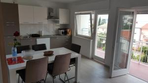a kitchen with a white table and chairs in a room at Vipava in Selce