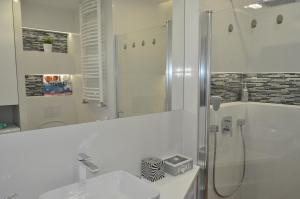 Un baño blanco con ducha y lavabo. en Klimatyzowany Apartament Paris, en Kielce 19 fotos más