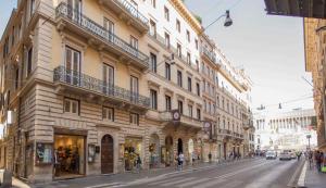 eine Straße mit Gebäuden und Menschen, die auf der Straße laufen in der Unterkunft Corso 277 Apartment in Rom