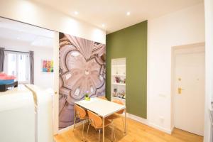 a dining room with a table and a painting on the wall at Corso 277 Apartment in Rome