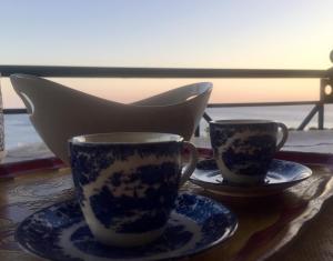 dos tazas y platillos sentados en una mesa en Lagonisi house en Aghia Marina