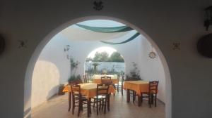 uma sala de jantar com um arco com mesas e cadeiras em Agriturismo Serra Vecchia em Giuggianello
