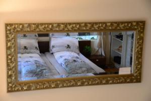 a mirror on a wall with a bed with pillows at It tunhuske in Renkum
