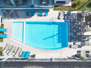 uma vista sobre uma grande piscina com cadeiras em Albatros Suites em Nea Vrasna