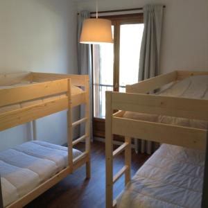 フォン・ロムー・オデイヨ・ヴィアにあるMontagne spacieux et confortableのベッドルーム1室(二段ベッド2台、窓付)が備わります。