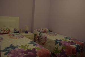 a bedroom with two beds and a dresser with a mirror at Apartamento Nek in San Sebastián de la Gomera