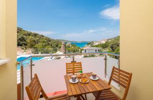Una mesa y sillas en un balcón con vista. en Villa Olive Tree, en Rogoznica