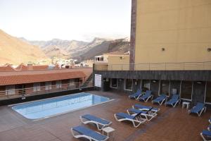a hotel with a swimming pool and lounge chairs at Apartamento Nek in San Sebastián de la Gomera