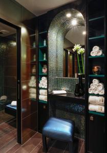 a bathroom with a stool and a mirror at Hôtel Tiffany by Fassbind in Geneva