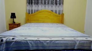 a bed with a wooden headboard in a bedroom at Bluebay Appartments in Blue Bay