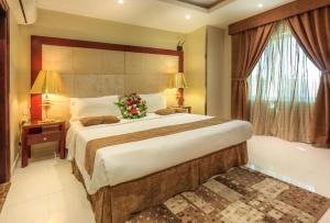 Un dormitorio con una cama grande con un arreglo floral. en Al Muhaidb Al Hada Resort en Al Hada