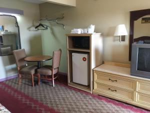 a living room with a tv and a chair at Ole Miss Motel in Oxford