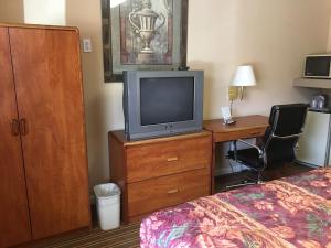 a hotel room with a bed and a television on a dresser at Ole Miss Motel in Oxford