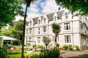 a white building with a palm tree in front of it at The Green House in Bournemouth