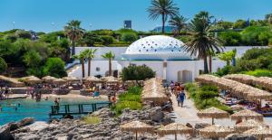a resort with a pool and a beach with umbrellas at Nicole's garden villa in Kallithea Rhodes