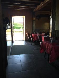 una sala da pranzo con tavoli e sedie rossi e un ingresso di Le Fauverney Lodge a Fauverney
