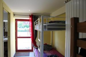 FauverneyにあるLe Fauverney Lodgeの二段ベッド2台とドアが備わる客室です。