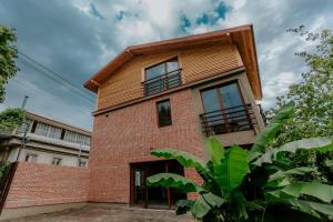 a brick house with a wooden roof at Sunset Telavi in Tʼelavi