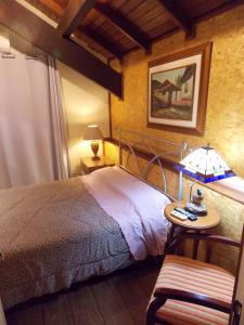 ein Schlafzimmer mit einem Bett und einem Tisch mit einer Lampe in der Unterkunft Sobrado no Centro de Canela in Canela
