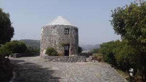 a small stone building with a roof on a stone road at Cabeço dos Três Moinhos in Rio Maior