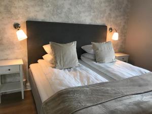 two beds in a bedroom with two lamps on the wall at Hotell Humbla in Sölvesborg