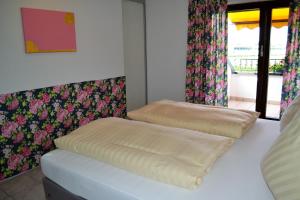a bedroom with two ottomans on a bed with flowers at Rennbahn - Life Iffezheim; Wohnen mit Rennbahnblick in Iffezheim