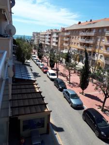 een rij auto's geparkeerd op een straat met gebouwen bij La Rambleta in L'Ametlla de Mar