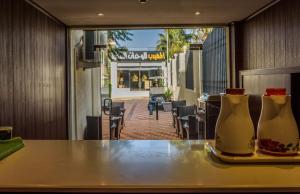 Al Muhaidb Residence for Chalets and Holidays Homes المهيدب ريزدنس لبيوت العطلات في الهدا: مزهريتين جالسين على طاولة في مطعم