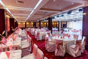 a banquet hall with white tables and white chairs at Hotel Rostov in Pleven