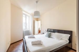 una camera da letto con un letto con lenzuola bianche e una finestra di LE RONDINELLE Apartment Bellagio a Bellagio