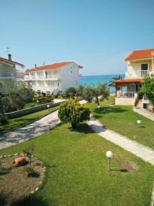 a view of a yard with houses and the ocean at Aello Sea-Seafront Apartments in Skála Foúrkas