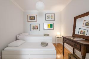 een woonkamer met een witte bank en een spiegel bij LisbonSpot58 in Lissabon