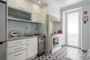 eine Küche mit weißen Schränken und Fliesenboden in der Unterkunft LisbonSpot58 in Lissabon