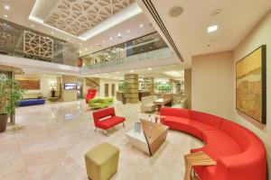 a hospital lobby with a red couch and chairs at Ramada By Wyndham İstanbul Taksim in Istanbul +37 photos