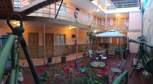 uma varanda de um edifício com mesas e um guarda-chuva em Hotel CostaFósil em Caldera