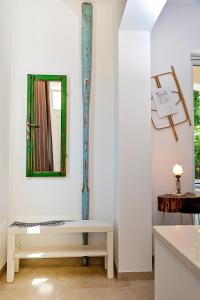 Habitación blanca con espejo y banco en Arka Trogir apartments - Seget Vranjica, en Seget Vranjica