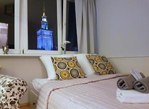 - une chambre avec un lit doté d'une tour d'horloge dans la fenêtre dans l'établissement A.G-Apartamenty Warszawa Centrum, à Varsovie