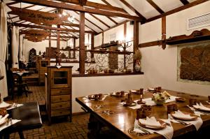 uma sala de jantar com uma grande mesa de madeira em Hotel Bellaria em Iaşi