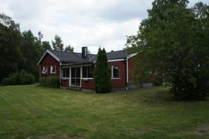 una casa roja con un patio delante en Kalv-Fegen 1, en Kalv