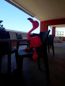 un toyanimal rojo sentado en una silla en una mesa en Mistral Exclusive B&B, en Gallipoli
