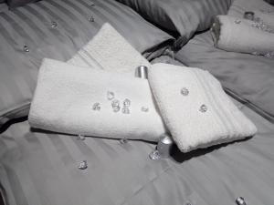 un letto con asciugamani e cuscini bianchi di N&L a Banja Luka